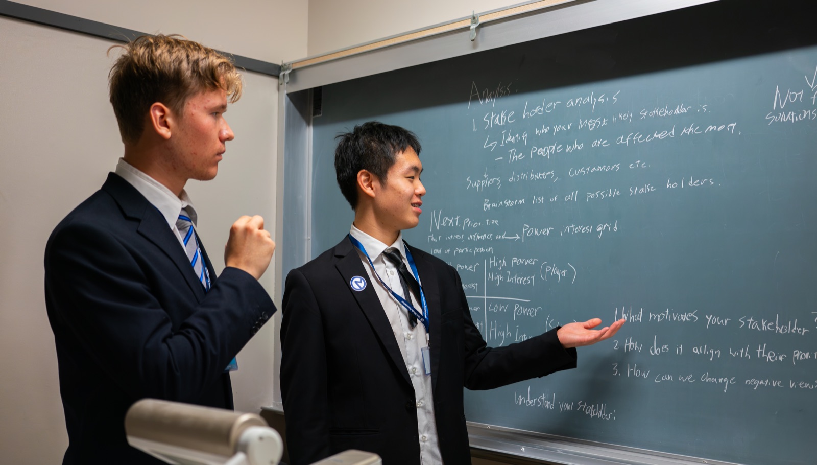 Two students working through the case on a chalkboard