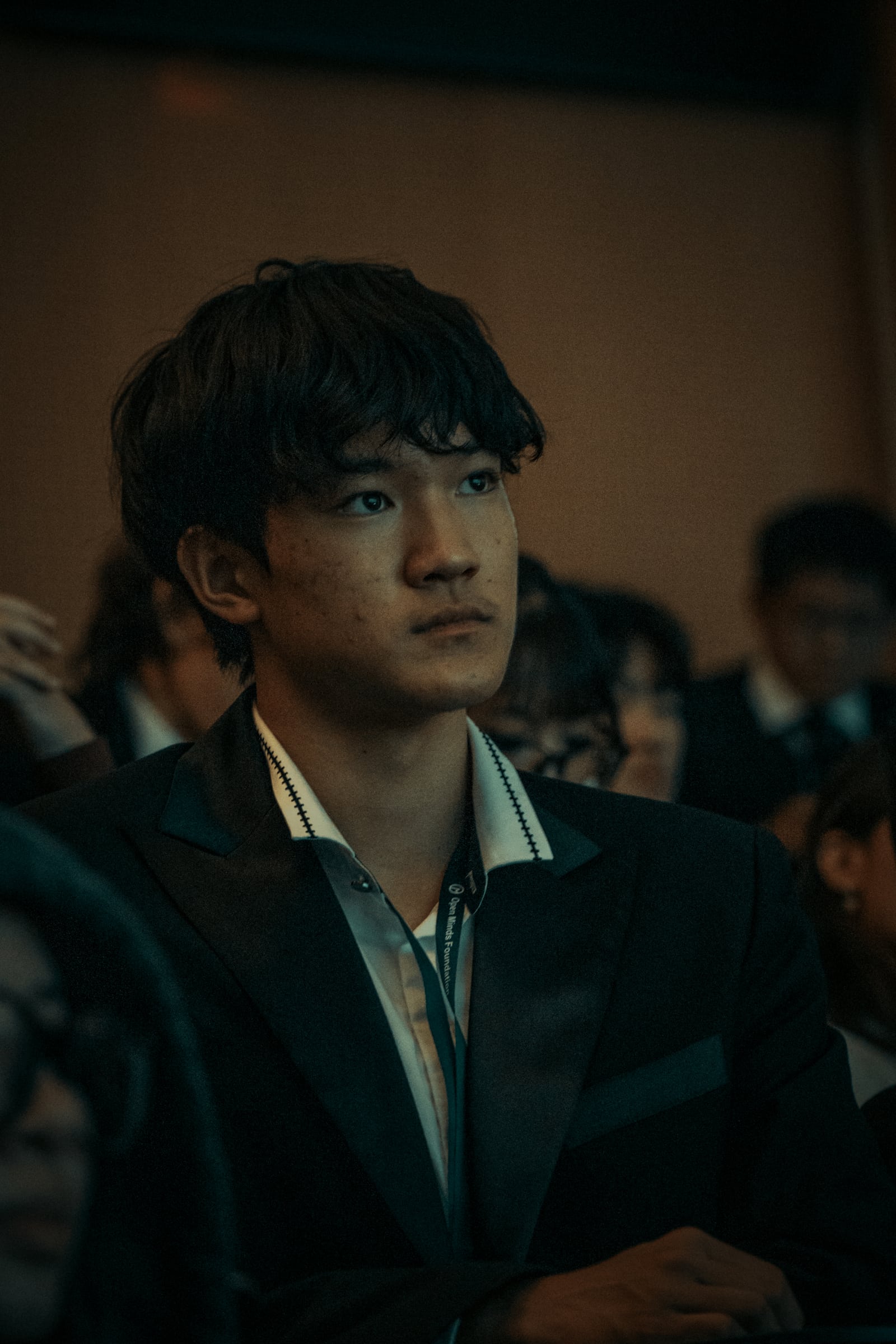 A student in a suit listening during the presentations